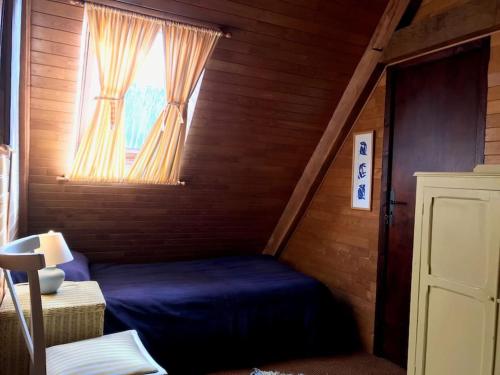 - une chambre avec un lit bleu et une fenêtre dans l'établissement Maison Médiévale, à Dinan