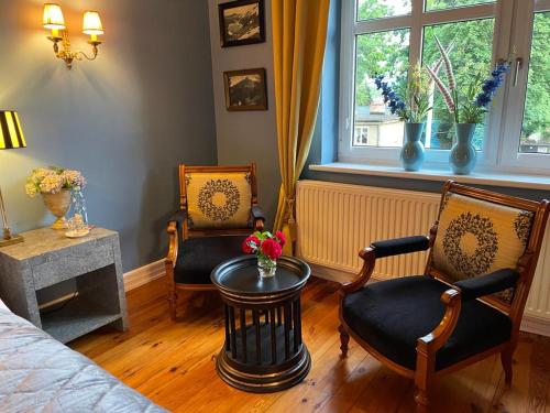 a bedroom with two chairs and a table and a bed at Villa Klara Cieplice in Jelenia Góra