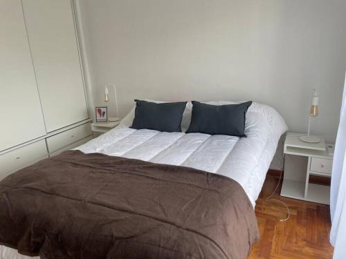 um quarto com uma cama grande e 2 almofadas azuis em Cómodo dos ambientes em Buenos Aires