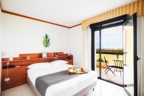 een slaapkamer met een bed en een glazen schuifdeur bij Hotel Residence Federiciano in Valenzano