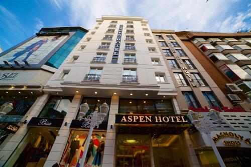 een hoog wit gebouw met een bord ervoor bij Aspen Hotel & SPA Istanbul Old City in Istanbul