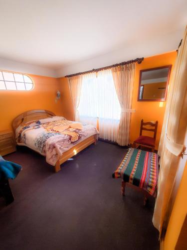 um quarto com uma cama, uma cadeira e uma janela em Cabañas Utama em Copacabana