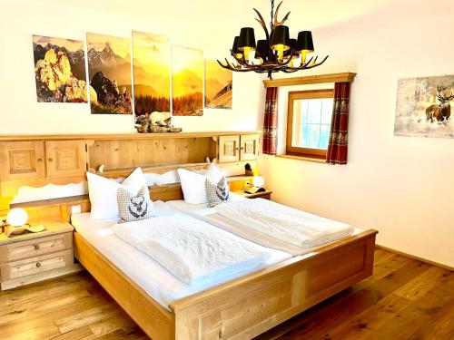 een slaapkamer met een groot bed en een kroonluchter bij Chalet Bernardi Apartments in Ortisei