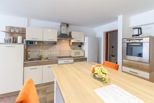 een keuken met een houten tafel met bloemen erop bij Déli Terasz A Apartman Free parking, self-check-in anytime in Győr