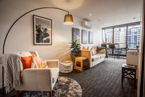 a living room with a couch and a table at ‘Sunrise on Aura’ Apartment with stunning views. in Melbourne