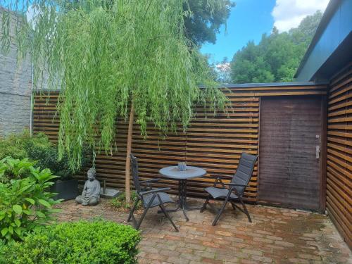 un patio con mesa y sillas bajo un árbol en Apartment Junger-Moritz, en Erfurt