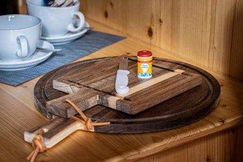 un tavolo di legno con un tagliere in legno con un barattolo sopra di Haus BergGesundZeit Doppelzimmer Kärlingerhaus a Schönau am Königssee