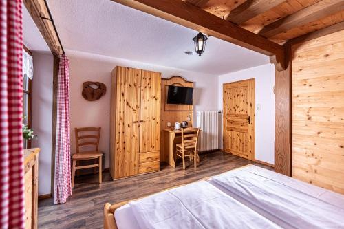 una camera con letto, scrivania e TV di Haus BergGesundZeit Doppelzimmer Kärlingerhaus a Schönau am Königssee