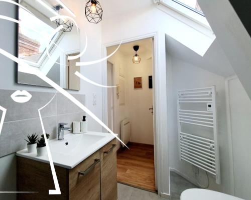 a bathroom with a sink and a skylight at Pop & Suite par Madame Conciergerie in Rennes