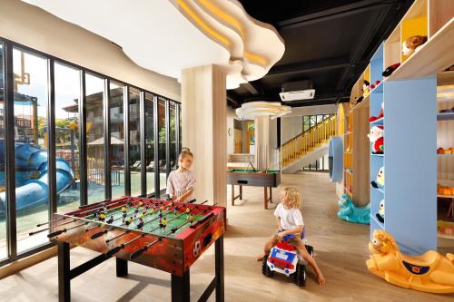 two children playing in a play room with a foosball table at Bali Dynasty Resort in Kuta