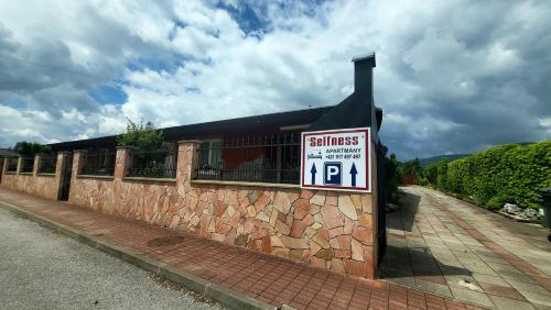 a building with a sign on a brick wall at Selfness Rožňava in Rožňava