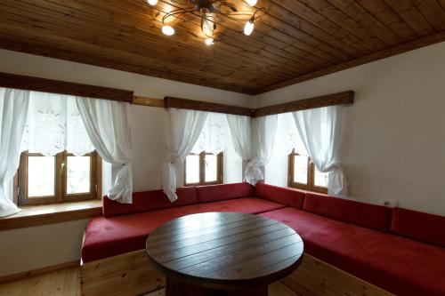 ein Wohnzimmer mit einem roten Sofa und einem Holztisch in der Unterkunft Hotel Sarajet 1821 in Gjirokastër