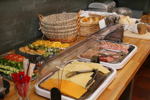 een buffet met eten op een houten tafel bij Lake and Cityhotel Edelweiss - self Check in in Zell am See