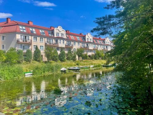 - une vue sur une rivière en face d'un bâtiment dans l'établissement Nowoczesny Apartament z widokiem na rzekę i jezioro, à Ełk