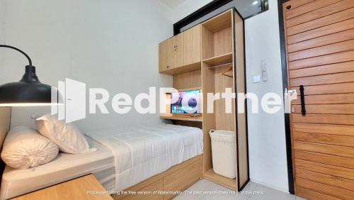 Dormitorio pequeño con cama y armario en Griya Nawastika At Jakal KM 8 Mitra RedDoorz, en Kejayan