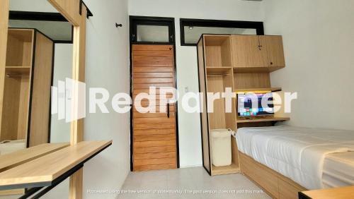 1 dormitorio con 1 cama y TV. en Griya Nawastika At Jakal KM 8 Mitra RedDoorz, en Kejayan