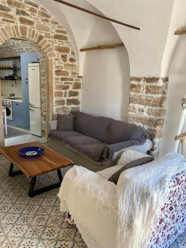 a living room with a couch and a table at Cozy stone built apartment in Nénita! in Chios