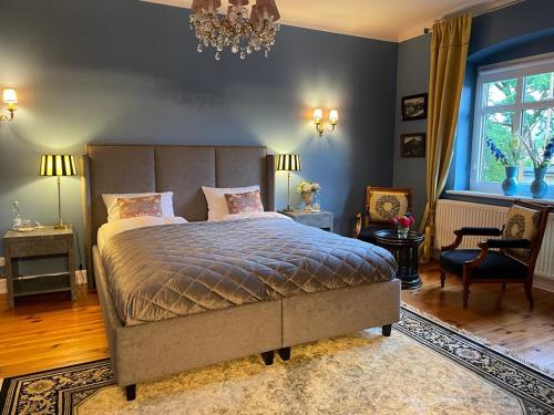 a bedroom with a large bed and a chandelier at Villa Klara Cieplice in Jelenia Góra