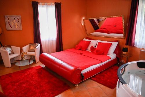 una camera con letto rosso e specchio di Loveroom a Interlaken