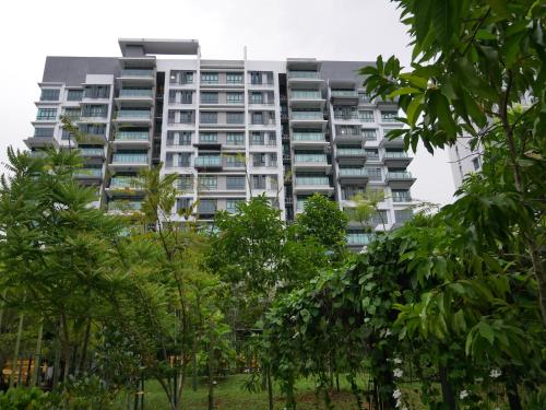 un edificio de apartamentos alto con árboles delante de él en Jome Putrajaya Presint 8 Natural Homestay, en Putrajaya