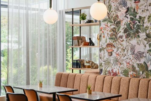 a living room with two tables and a couch at Hotel Berlin, Berlin, a member of Radisson Individuals in Berlin