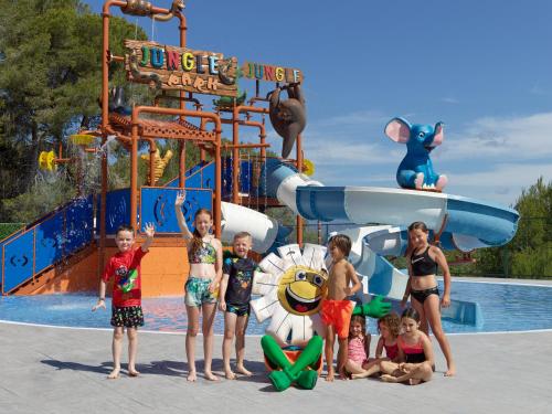 um grupo de crianças em pé em frente a um parque aquático em H10 Mediterranean Village em Salou