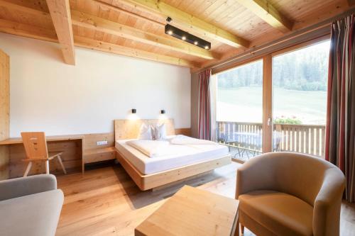 um quarto com uma cama e uma grande janela em LifestylePanoramaHotel Erika Superior em Neustift im Stubaital