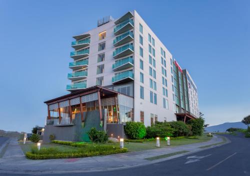 ein großes weißes Gebäude an der Straßenseite in der Unterkunft Sheraton San Jose Hotel, Costa Rica in San José