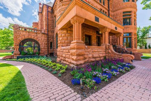 un bâtiment en briques avec des fleurs devant lui dans l'établissement Orman Mansion - Pueblo's Most Luxurious Stay!, à Pueblo