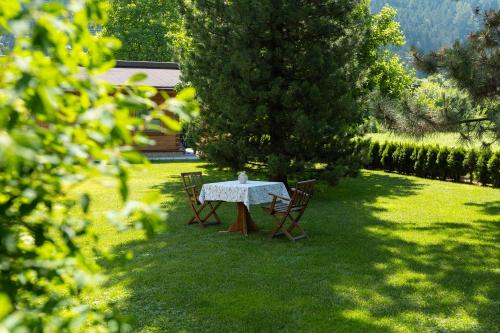 stół i krzesła na dziedzińcu z drzewem w obiekcie Hotel Garni Jagdhof w mieście Zell am Ziller