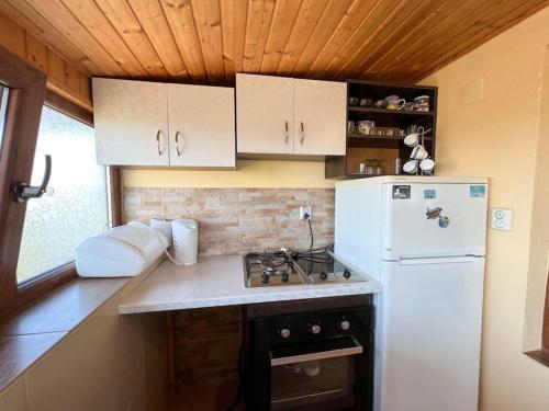 a kitchen with a white refrigerator and a stove at Guest House Italia in Kavarna