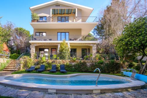 une villa avec une piscine en face d'une maison dans l'établissement Casa Vela Boutique House, à Cascais