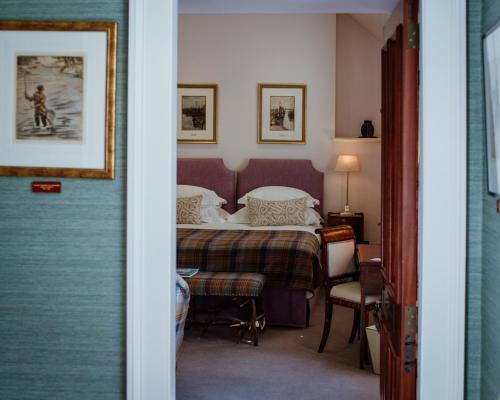 una camera con letto, tavolo e sedie di Links House at Royal Dornoch a Dornoch