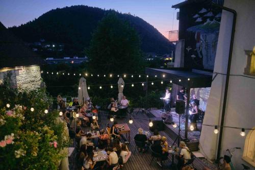 um grupo de pessoas sentadas a mesas num pátio à noite em Layer Residences em Kranj