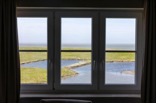 una finestra con tre viste sull'oceano di Anker's Hörn - Hotel & Restaurant auf der Hallig Langeness a Langeness