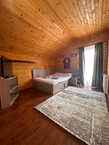 - une chambre avec un lit et un tapis dans l'établissement Ollie's Mountain Chalet, à Buşteni