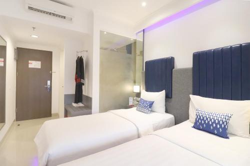 a bedroom with two beds and a mirror at Moritz Biz Gandaria in Jakarta