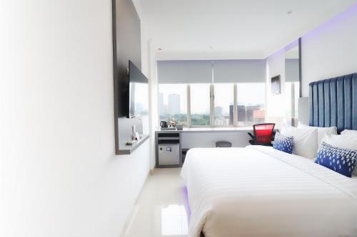 a hotel room with two beds and a television at Moritz Biz Gandaria in Jakarta