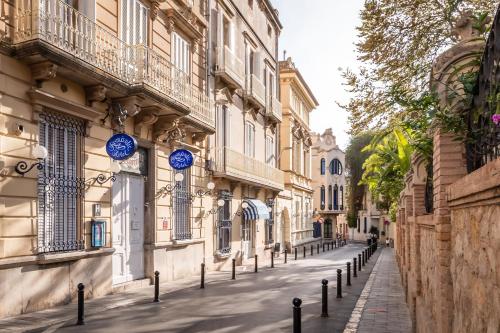 une rue dans une ville avec des panneaux bleus sur les bâtiments dans l'établissement Hotel Medium Romantic, à Sitges