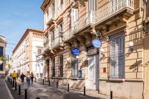 un bâtiment avec des panneaux bleus sur le côté d'une rue dans l'établissement Hotel Medium Romantic, à Sitges