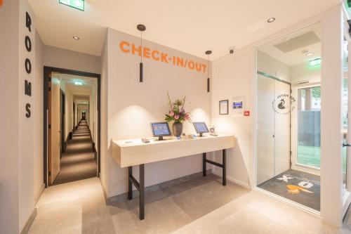 ein Ankleidezimmer mit einem Schreibtisch und einem Flur in der Unterkunft Fox Hotel The Hague Scheveningen in Scheveningen