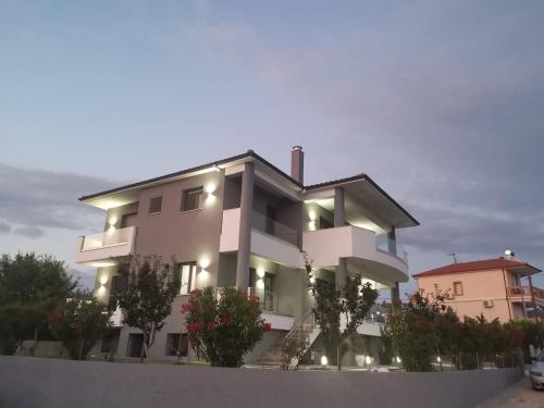 un gran edificio blanco con luces encendidas en Il Grigio Apartments, en Limenaria