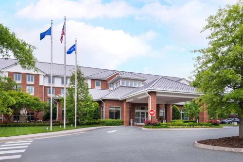 un hôtel avec drapeaux devant un bâtiment dans l'établissement Hilton Garden Inn Charlottesville, à Charlottesville