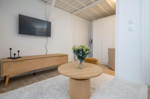 uma sala de estar com um vaso de flores sobre uma mesa em Studio Part Dieu em Lyon