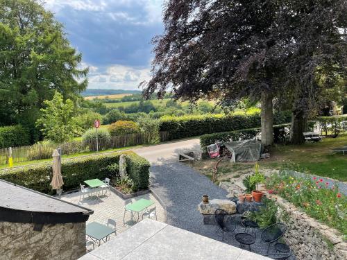 - une vue aérienne sur un jardin avec des tables et des chaises dans l'établissement L'Art de la fugue, à Daverdisse