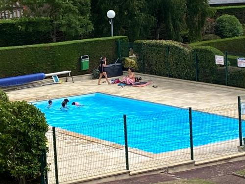 een groep mensen in een zwembad bij Picsine, Tennis résidence sévigné 300m mer in Deauville