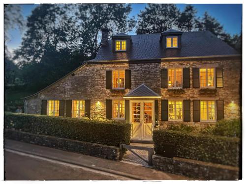 une grande maison en pierre avec ses lumières allumées dans l'établissement L'Art de la fugue, à Daverdisse