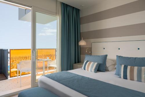 um quarto de hotel com uma cama e uma varanda em Hotel Orient & Pacific em Lido di Jesolo