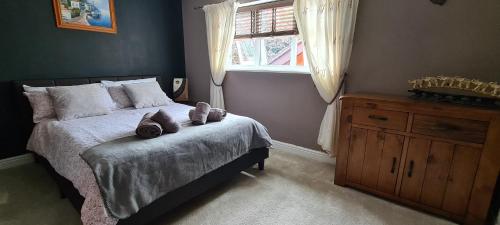 una camera con un letto con una finestra e un comò di Spacious, 5 bed house for 9 in Chester a Chester