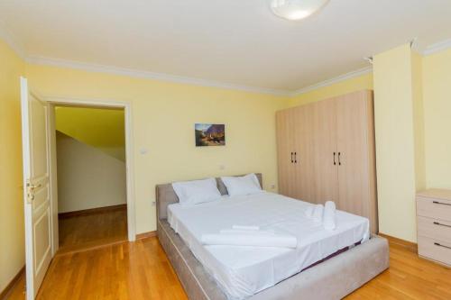 - une chambre avec un grand lit blanc dans l'établissement Vila Oliva, à Herceg-Novi